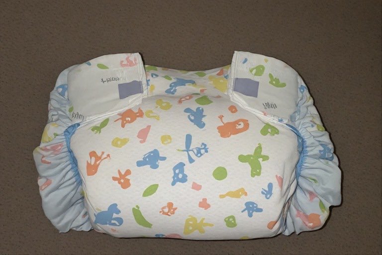 Illustrative photograph of an adult diaper arranged against a neutral background